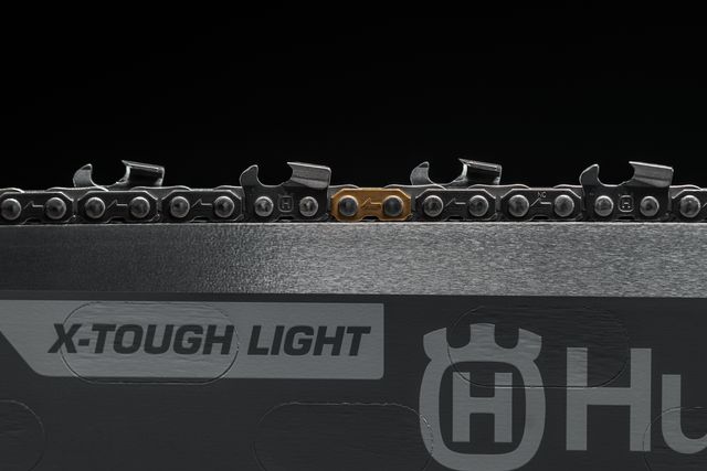 Close-up of a chainsaw chain on a bar labeled 'X-Tough Light'.