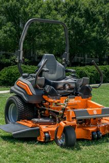 A Husqvarna ride-on mower parked on a grassy lawn, ready for use.