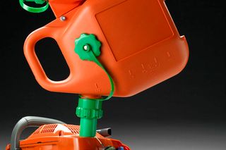 Side view of a fuel container attached to a power tool.