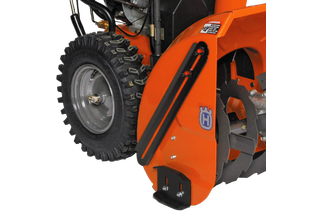 Close-up view of a Husqvarna snow blower attachment with visible auger and tire.