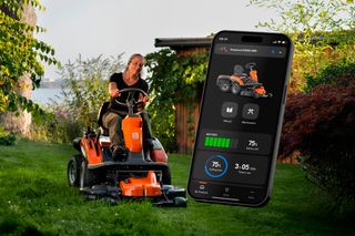 A person mowing lawn with a ride-on mower in a garden, with a smartphone app showing mower status.