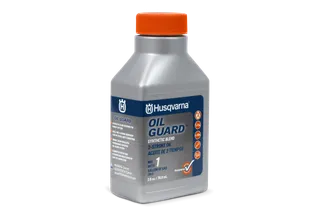 Front view of a Husqvarna Oil Guard bottle, showcasing its label and safety instructions.